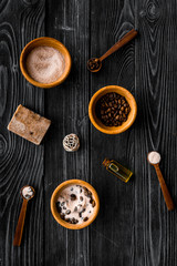 Aromatheraphy in spa. Chocolate brown spa salt and soap on black wooden background top view