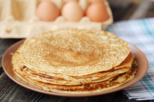 Fresh pancakes and eggs on a wooden table