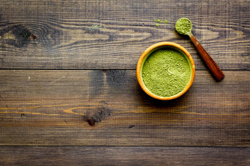 Japanese traditional product. Matcha green tea in bowl on dark wooden background top view copy space
