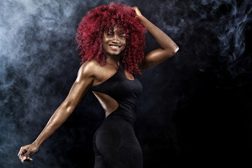 Sporty beautiful afro-american model, woman in sportwear makes fitness exercising at black background to stay fit