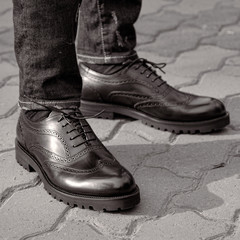A man in the street wearing black shoes