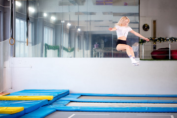 Twine young woman jumping on trampoline club