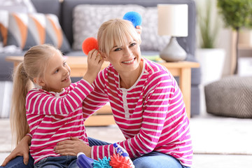 Little girl and her mother playing while cleaning up at home