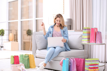 Beautiful woman with laptop and credit card at home. Online shopping concept