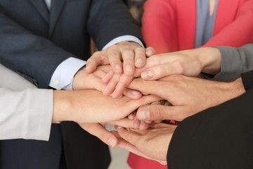 Group of people putting hands together as symbol of unity