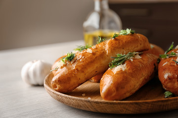 Plate with delicious homemade garlic bread on table