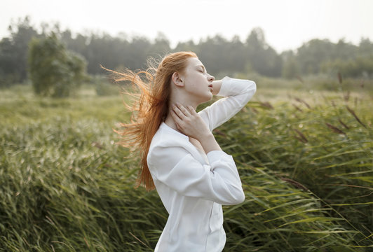 Wind blowing hair of Caucasian woman in field