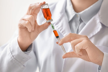 Doctor holding syringe and medicine for vaccination, closeup