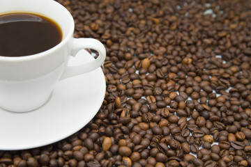 Coffee cup and coffee beans on wooden background