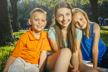 Portrait of smiling Caucasian brother and sisters in park