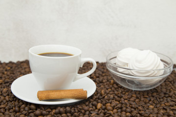 Coffee cup, straws, marshmallows and coffee beans on wooden background