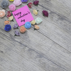 Fototapeta na wymiar Happy Valentine's day text on sticker. flowers on wood background.