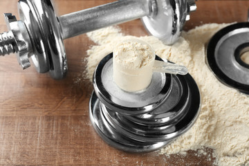 Measuring scoop with protein powder on  weight plates
