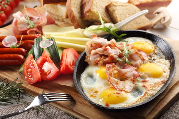 close up of rustic full english breakfast on a white wooden table