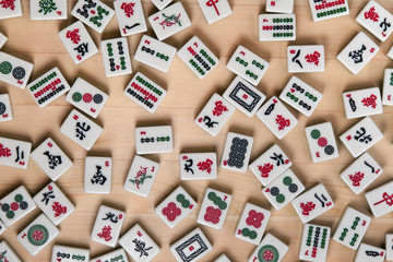 White-green tiles for mahjong on a brown wooden background.