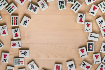 White-green tiles for mahjong on a background of light brown wood. Empty space in the center