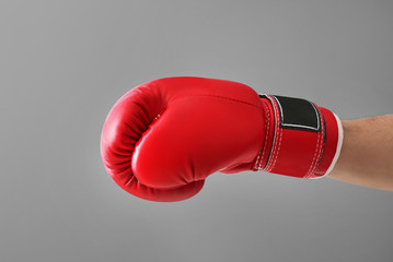 Man in boxing glove on gray background