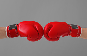 Men in boxing gloves on gray background