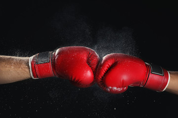 Men in boxing gloves on black background