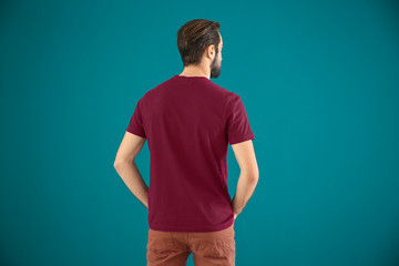 Young man in stylish t-shirt on color background. Mockup for design