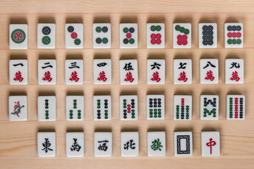 White-green tiles for mahjong on a brown wooden background.