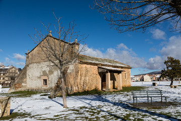 Fototapeta na wymiar Hermitage of San Roque surrounded by snow fallen in the park