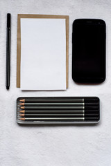 Oficce tools. Home office. Phone, notes, pencils and pen on white background.