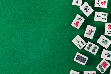 White-green tiles for mahjong on on green cloth background. Emty space on the left