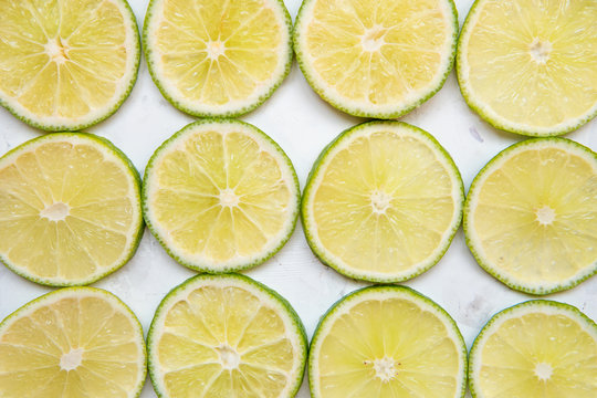 Lime slices in rows on a light background top view