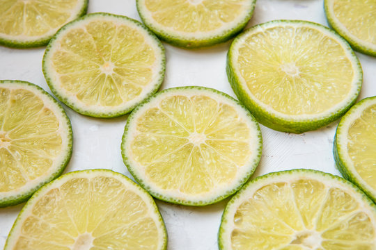 Lime slices in rows on a light background top view