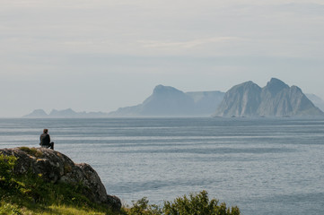 End of the road in Lofoten. Route E10 ends at Å, Moskenes in the southernmost part of the Lofoten archipelago. Unrecognizable tourist enjoys the view towards Vaeröya.