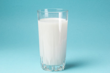A glass of milk on a blue background.