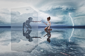 Woman in cube reaching to kneeling girl