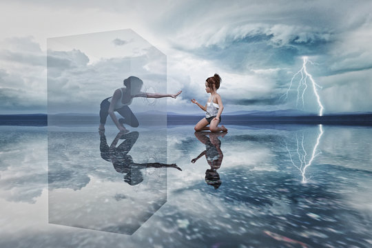 Woman in cube reaching to kneeling girl