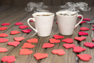 two cups of coffee, figures of hearts, on a wooden table. romantic date a couple, love.