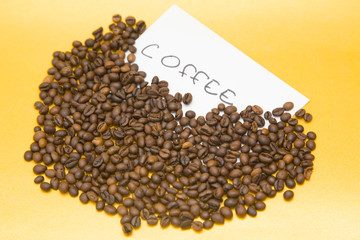 Coffee beans on yellow background. Copyspace and closeup