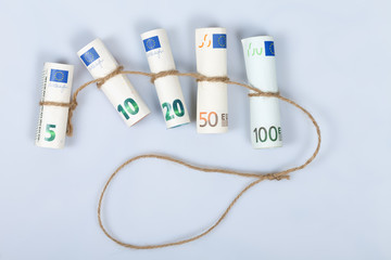 The most used euro bills for Europeans tied with a rope and isolated on white