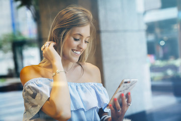 Smiling Caucasian woman texting on cell phone