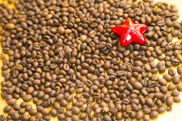 I love coffee concept. Coffee beans and red star on yellow background. Copyspace and closeup