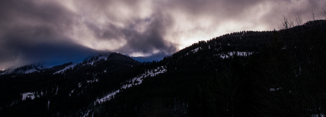 sunset behind the mountains. Cold anc cloudy. It is going to be dark.