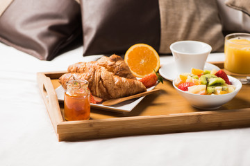 Tray with breakfast food on the bed inside a bedroom