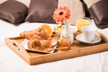 Tray with breakfast food on the bed inside a bedroom