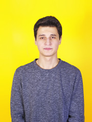 Confused young man looking at camera shyness, shame or humiliation isolated on a yellow background.