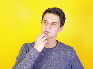 Portrait of a thoughtful young man, isolated on a light background