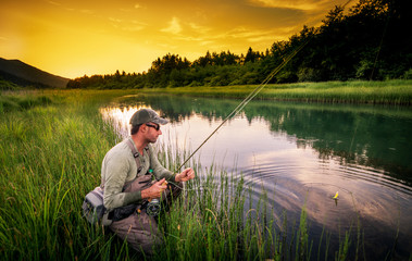 Fly fisherman fishing pike in river