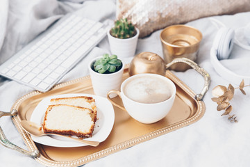 Lifestyle composition with cup of coffee. Freelance work at home. Breakfast in bed