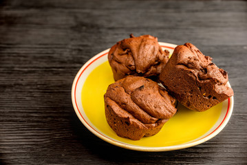 muffins on a yellow plate on a black wooden background