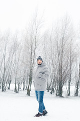 Fototapeta na wymiar a man in a gray jacket in a winter forest