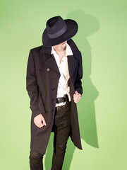 Young man gangster hides a gun under the belt of jeans