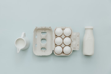 Milk and eggs on pastel background, top view, flat lay, copy space. Preparation Baking Kitchen Table Ware